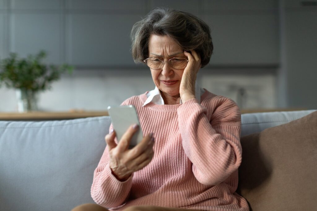 Older woman looking worried at her phone